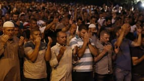 Des musulmans palestiniens prient devant l'enceinte de l'esplanade des mosquées à Jérusalem pour protester contre les contrôles par les autorités israéliennes, le 23 juillet 2017