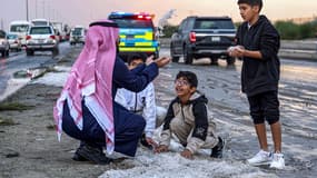 Un homme et des enfants à Oum al-Haïman après la tempête de grêle au Koweït le 27 décembre 2022