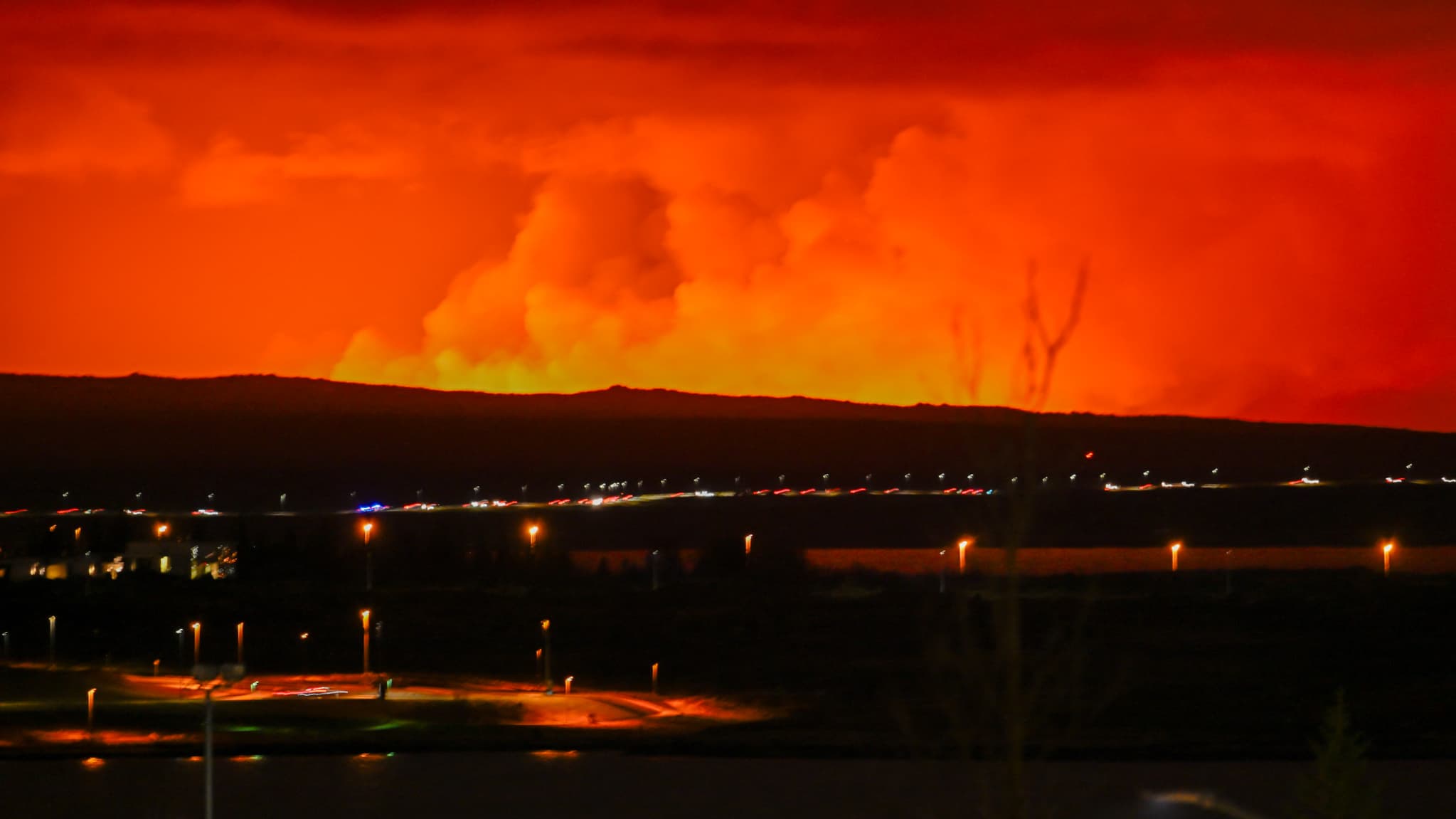 Le ciel orange lors d'une nouvelle éruption volcanique à la périphérie de la ville évacuée de Grindavik, dans l'ouest de l'Islande, le 16 mars 2024.