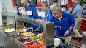 Thomas Bach, président du CIO, se sert à la cantine du village olympique, le 22 juillet 2024