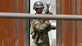Militaire surveillant l'entrée du ministère afghan de la Défense, à Kaboul, où un homme en uniforme a ouvert le feu lundi, faisant au moins deux morts et sept blessés. Les taliban ont dit avoir voulu s'en prendre au ministre français de la Défense, arrivé