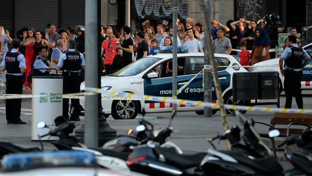 Des passants évacuant les lieux de l'attaque de Barcelone sous l'oeil de la police, le 17 août 2017.