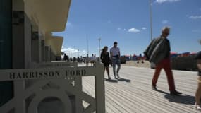 Des promeneurs sur les planches de Deauville (Calvados).