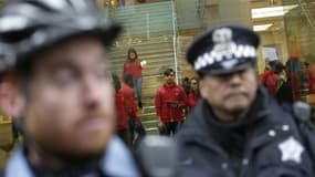 Un policier bloque l'entrée d'un magasin à Chicago, le 24 décembre 2015 lors d'une manifestation contre les violences policières