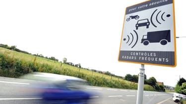 Une voiture passe à coté d'un panneau signalisant la présence d'un radar (Image d'illustration)