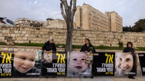Des militants palestiniens tiennent des images de la famille Bibas devant le bureau du premier ministre à Jérusalem le 3 février 2025.