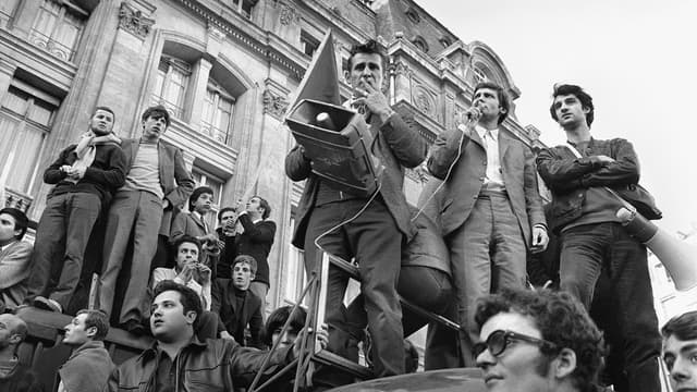 Jacques Sauvageot, l'un des trois leaders, avec Alain Geismar (1er plan, en bas, avec la veste de cuir) et Daniel Cohn-Bendit (non photographié) de "Mai 1968", et président de l'Unef, micro à la main, harangue des étudiants réunis le 08 juin 1968 devant la Gare Saint-Lazare à Paris.
