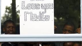 Des élèves d'une école proche de l'hôpital Milpark, à Johannesburg adressent leur soutien à Nelson Mandela, surnommé affectueusement "Madiba" (son nom de clan) par les Sud-Africains. L'ancien président sud-africain subit des examens médicaux poussés à l'h