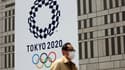 Un piéton passe devant le logo officiel des Jeux olympiques 2020 à Tokyo le 7 avril 2021
