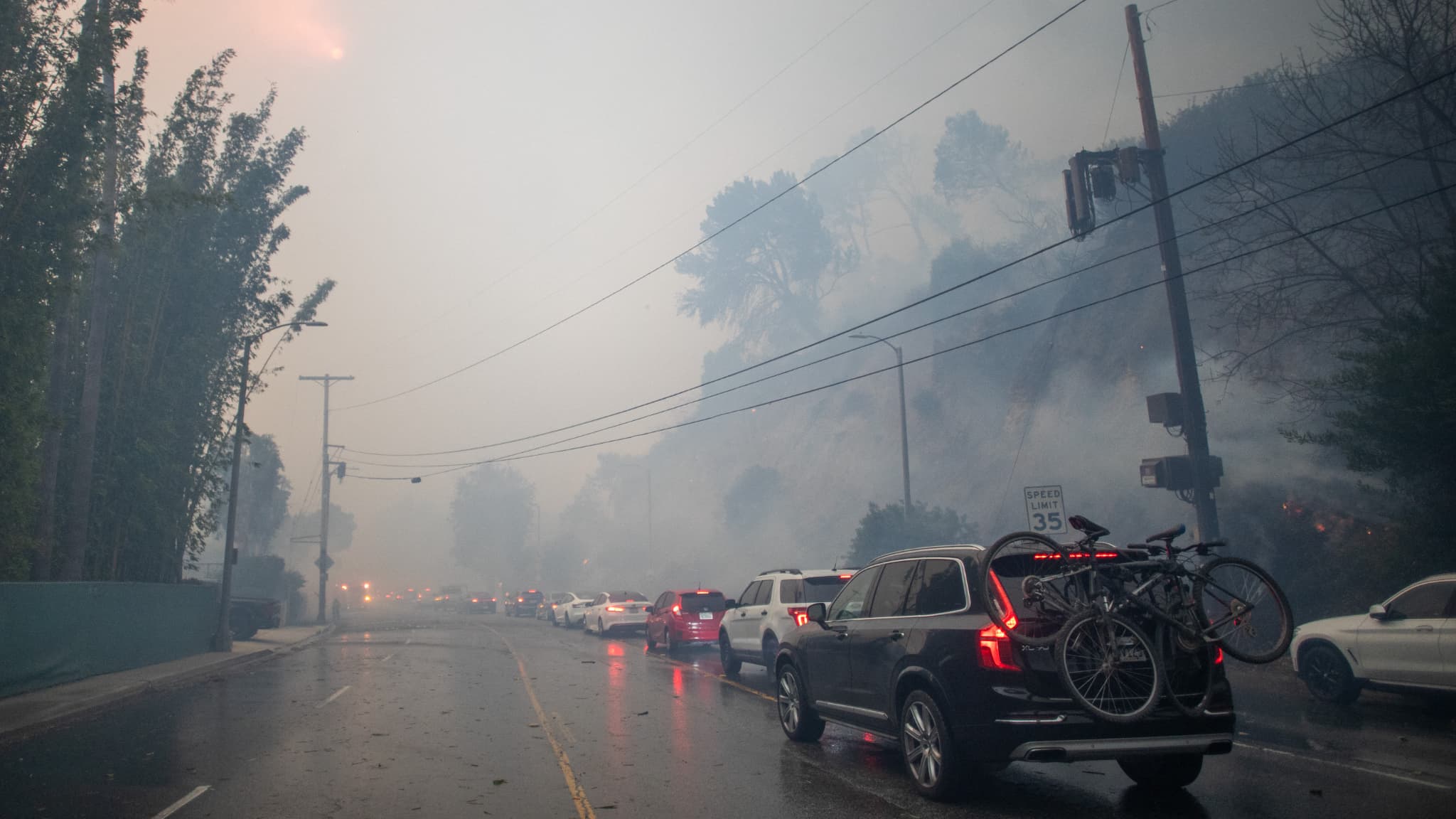 Des gens conduisent leur voiture sur Sunset Boulevard alors qu'ils évacuent leur maison pendant que l'incendie de Palisades brûle au cours d'une puissante tempête de vent, le 7 janvier 2025 à Pacific Palisades, en Californie.