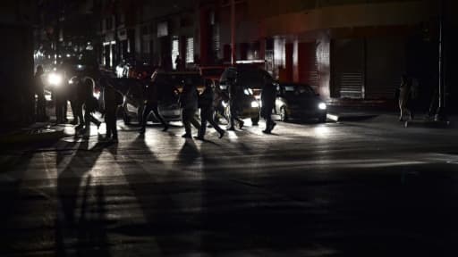 Des gens traversent une rue de Caracas pendant la gigantesque panne d'électricité, le 7 mars 2019