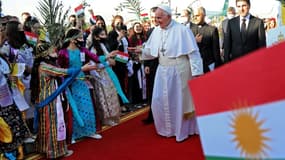 Le pape accueilli par des enfants en habit traditionnel kurde à l'aéroport d'Erbil, dans le nord de l'Irak, le 7 mars 2021 