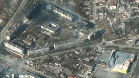 Cette photo satellite prise par la société Maxar satelitte le 18 mars 2022 montre des bâtiments d'habitation et des commerces de Marioupol (Ukraine) en flammes et très endommagés