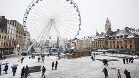 Cette photographie prise le 17 janvier 2024 montre une vue générale de la grande roue de la Grand'Place de Lille, dans le nord de la France, lors d'une chute de neige.