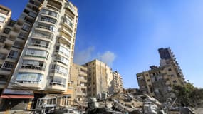 Un automobiliste conduit un scooter devant les décombres d'un immeuble effondré, cible d'une frappe aérienne israélienne dans la banlieue sud de Beyrouth, à Shayah, le 22 octobre 2024. 