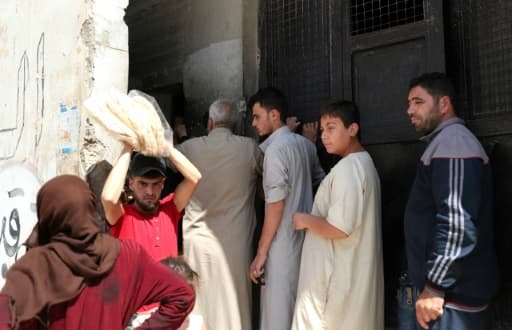 Des Syriens achètent du pain à Bennich, dans le nord-ouest de la région d'Idleb, en Syrie, le 9 juin 2020 Des Syriens achètent du pain à Bennich, dans le nord-ouest de la région d'Idleb, en Syrie, le 9 juin 2020