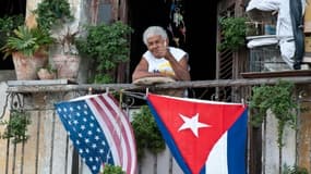 Un habitant de La Havane salue depuis son balcon décoré avec les drapeaux américains et cubains, pour célébrer en janvier 2015 l'annonce du rapprochement entre les deux pays.