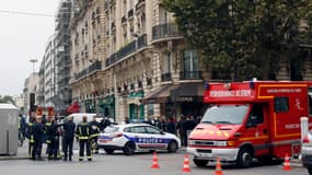 Des sapeurs pompiers se tiennent en bas d'un immeuble dans lequel deux "personnes âgées" sont décédées en 2012 à Paris à cause du monoxyde de carbone