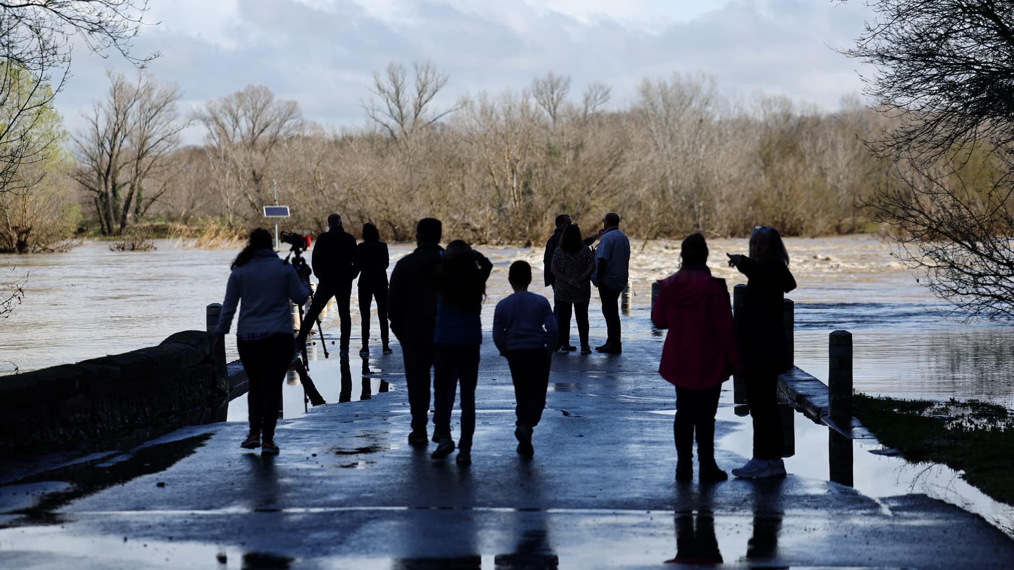 Des gens observent le pont submergé à Dions. Des gens observent le pont submergé à Dions.
