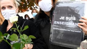 Des femmes rendent hommage au professeur assassiné devant son collège à Conflans Saint-Honorine, le 17 octobre 2020