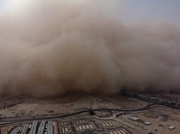 Cette photo prise le 23 mai 2022 montre une vue aérienne d'une énorme tempête de poussière qui progresse dans la ville de Koweït au-dessus du campus de l'université de Koweït.
