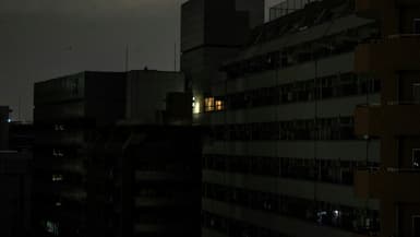 Vue générale d'immeubles d'habitation pendant une coupure de courant due à un séisme, à Tokyo le 16 mars 2022