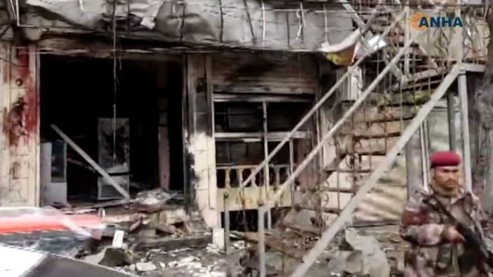 Un membre des forces de sécurité sur la scène de l'attaque suicide qui a lieu à Manjib ce 16 janvier 2019.