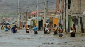 Des habitants de la commune de Huarmey, cité portuaire à 300 kilomètres au nord du Pérou est encerclée par la boue depuis les pluies diluviennes qui ont balayé le pays ces derniers jours, le 19 mars 2017