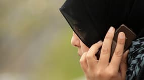 Une femme musulmane en pleine conversation téléphonique.