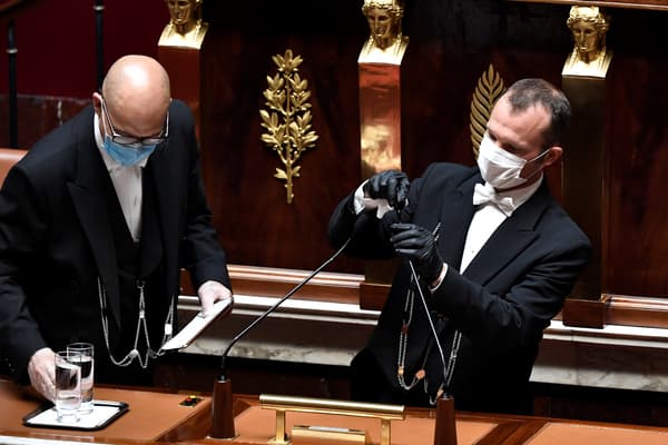 Des huissiers de l'Assemblée nationale apportent des verres d'eau et désinfectent le micro, en juin 2020.