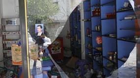 Un portrait de Bachar al Assad sur la vitrine détruite d'une boutique à Haffeh, dans l'ouest de la Syrie. Le ministre français des Affaires étrangères Laurent Fabius a confirmé vendredi sur France Inter que la France, les Etats-Unis, la Russie et d'autres