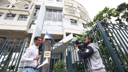 Entrée du commissariat central de Saint-Denis à La Réunion le 2 juin 2015, où un cameraman filme un journaliste relatant l'arrestation d'un groupe présumé de jihadistes