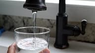 Un verre d'eau coulant du robinet (illustration).