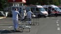 Des ambulanciers pour des chariots vers l'entrée d'un hôpital pour transporter des patients atteints du Covid-19 arrivés en ambulance, le 30 octobre 2020 à Tirana, en Albanie