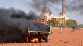 Camion de police en feu à Niamey au Niger, le 17 décembre 2015. En fond, la grande mosquée de la ville.