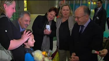 Enzo dans les bras de sa maman à gauche, face au ministre du Budget, à droite, lors d'émouvantes retrouvailles.
