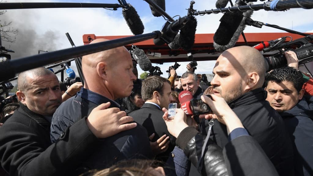 Emmanuel Macron entouré de ses gardes du corps, de perches de journalistes et d'ouvriers sur le parking de l'usine Whirlpool à Amiens le 26 avril 2017. Emmanuel Macron entouré de ses gardes du corps, de perches de journalistes et d'ouvriers sur le parking de l'usine Whirlpool à Amiens le 26 avril 2017.