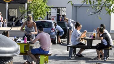 Des vacanciers en train de pique-niquer sur une aire d'autoroute de l'A7 entre Lyon et Vienne, dans le Sud-Est de la France samedi.