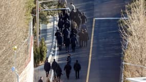 Des enquêteurs marchent en direction de la résidence du président déchu Yoon Suk Yeol, le 3 janvier 2024, pour tenter de l'arrêter