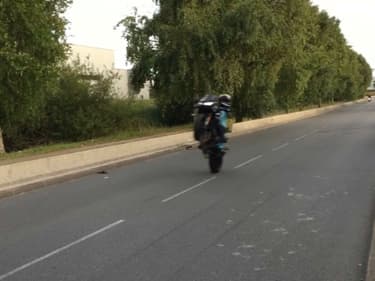 Un conducteur de deux-roues se livrant à un rodéo sauvage.