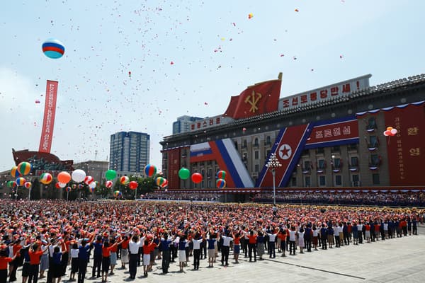 Des personnes lâchent des ballons en l'air alors que le président russe Vladimir Poutine et le dirigeant nord-coréen Kim Jong Un assistent à une cérémonie de bienvenue sur la place Kim Il Sung à Pyongyang, le 19 juin 2024. 