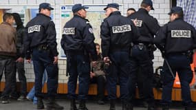Des policiers procédant à un contrôle dans une station de métro parisienne