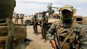 Des soldats des Forces démocratiques syriennes (SDF) et des soldats américains (g), le 1er mai 2018 à Boukamal, dans la province de Deir Ezzor