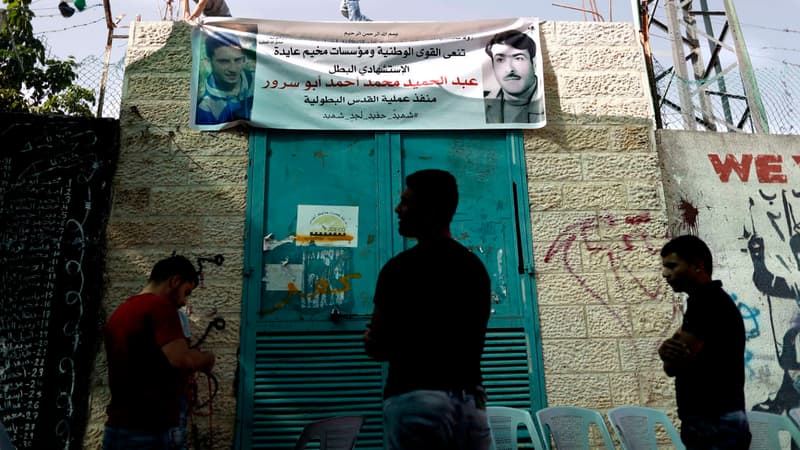 La jeunesse palestinienne debout face à une affiche présentant un portrait de l'auteur présumé de l'attaque contre un bus israélien, le 20 avril 2016. 