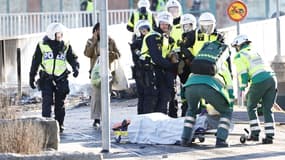 Des policiers et des secours prenant en charge un policier à Norrköping en Suède le 17 avril 2022.