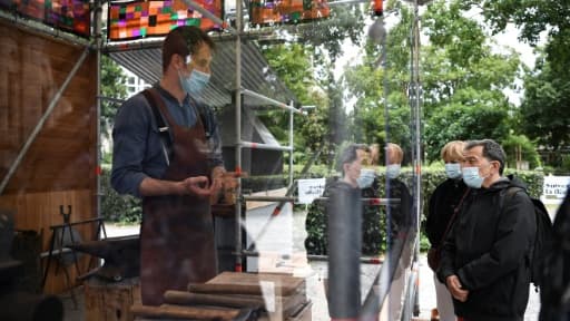 Un forgeron explique son travail et montre les gestes médiévaux à des visiteurs, le 5 juin 2020 devant la basilique de Saint-Denis