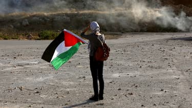 Une manifestante brandit un drapeau palestinien en signe de solidarité à Ofer, en Cisjordanie. L'Assemblée nationale se prononcera, le 2 décembre, sur une proposition de résolution socialiste sur la reconnaissance d'un Etat de Palestine.
