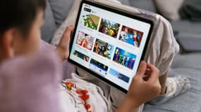 Un enfant de 7 ans regarde l'écran de son iPad sur lequel l'application YouTube Kids est ouverte, le 7 décembre 2025 à Sydney, en Australie