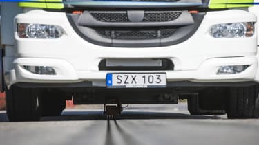 L'énergie électrique est transférée grâce à un bras amovible situé sous le véhicule qui entre en contact avec le rail situé au milieu de la route.