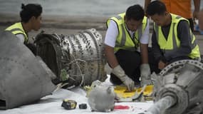 Des experts examinant les restes du moteur du Boeing de la compagnie Lion Air.
